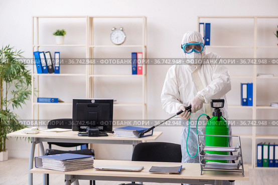 Old male contractor in office disinfection concept. Стоковое фото, фотограф Elnur / Фотобанк Лори