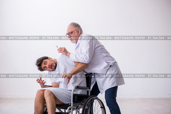 Old male doctor psychiatrist examining young disabled patient. Стоковое фото, фотограф Elnur / Фотобанк Лори