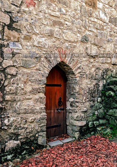old wooden door in a stone wall with green moss and fallen autumn yellow leaves. Стоковое фото, фотограф Артем Курутин / Фотобанк Лори
