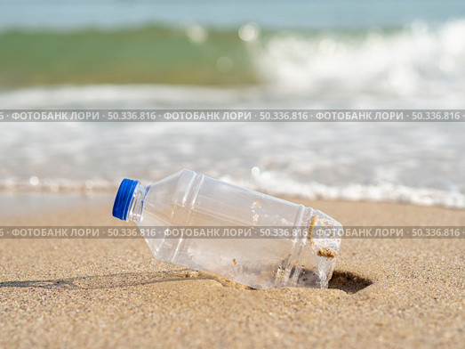 OLYMPUS DIGITAL CAMERA. plastic bottle left beach. Стоковое фото, агентство Ingram Publishing / Фотобанк Лори