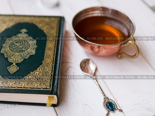 OLYMPUS DIGITAL CAMERA. top view arrangement with quran tea spoon. Редакционное фото, агентство Ingram Publishing / Фотобанк Лори
