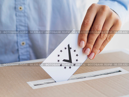 OLYMPUS DIGITAL CAMERA. woman putting checked european ballot box. Стоковое фото, агентство Ingram Publishing / Фотобанк Лори