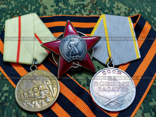 Орден «Красная Звезда» и медали "За оборону Сталинграда", "За боевые заслуги" на георгиевской ленте. Награды фронтовика. Семейная реликвия. Память. 9 мая День Победы. Стоковое фото, фотограф Сергей Елизарьев / Фотобанк Лори