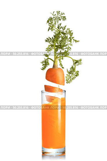 Organic natural fresh carrot root with green leaf in the glass of juice on a white background, copy space. Vegetarian concept.. Carrot root falls in a glass of fresh juice. Стоковое фото, агентство Ingram Publishing / Фотобанк Лори