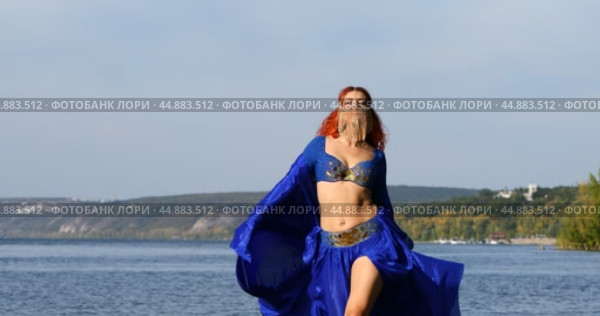 Oriental dances - young beautiful woman dancing on the beach. Стоковое видео, видеограф Андрей Аркуша / Фотобанк Лори
