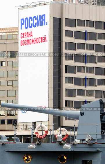 Орудие Авроры на фоне баннера. (Фокус на баннере) (2011 год). Редакционное фото, фотограф Сергей Разживин / Фотобанк Лори
