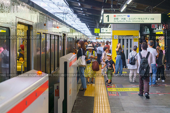 Osaka, Japan - Sep 22 2024, Panoramic view of the platform of the railway station with an electric train from which people enter and exit, JR Osaka Station, at daytime, Osaka, Japan. Редакционное фото, фотограф Сергей Богомяко / Фотобанк Лори