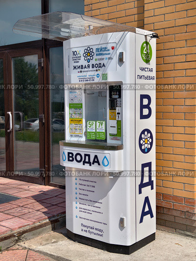 Outdoor water vending machine with purified drinking water near brick wall of convenience store. Редакционное фото, фотограф Сергей Пристяжнюк (Serg Zastavkin) / Фотобанк Лори