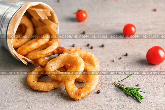 Overturned bucket with tasty onion rings on table. Стоковое фото, фотограф Pixel_shot / Фотобанк Лори