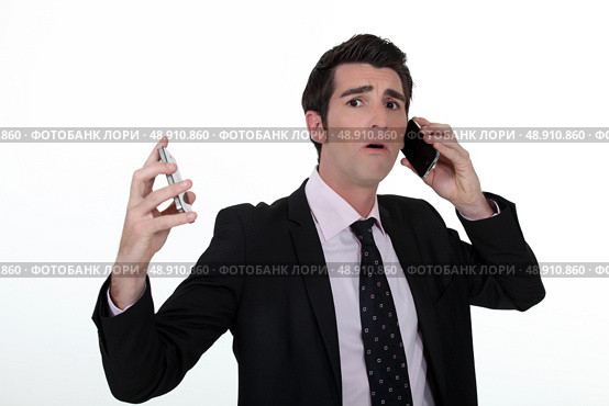 Overwhelmed businessman answering telephones. Стоковое фото, агентство Ingram Publishing / Фотобанк Лори