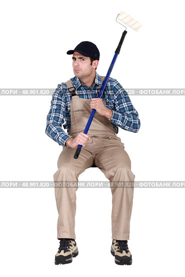 painter sulking and holding a roller. Стоковое фото, агентство Ingram Publishing / Фотобанк Лори