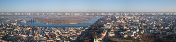 Panorama of kyiv, District Podol and St. Andrew’s Church, Pochtovaya Ploschyad and the Dnieper River with Peshihodny and Podolsky bridges, left bank in the distance, Ukraine. Drone photo Full panorama 360. Panorama of Kiev, District Podol and the left bank, the Dnieper River on an April sunny day, Ukraine. Стоковое фото, агентство Ingram Publishing / Фотобанк Лори