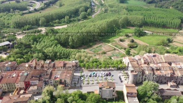 Panoramic aerial view of medieval walled village of Hostalric with reddish tiled roofs of residential buildings on summer day, Catalonia, Spain. Стоковое видео, видеограф Яков Филимонов / Фотобанк Лори