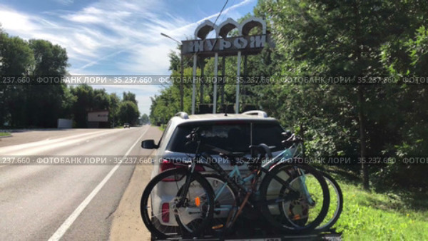 Passenger car with bike carrier stands roadside in front of sign of Murom town. Russian people travel by car across Russia during closed border (2021 год). Редакционное видео, видеограф Кекяляйнен Андрей / Фотобанк Лори