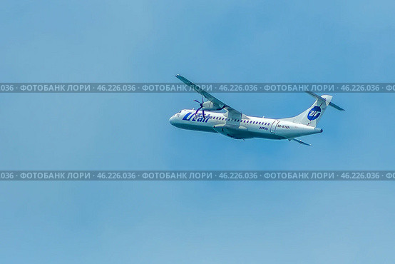 Passenger plane of Russian airline Utair in flight in sky. Turboprop civil aviation aircraft gaining altitude in the air. (2022 год). Редакционное фото, фотограф Елена Серебрякова / Фотобанк Лори