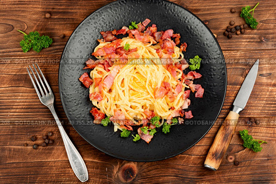 Pasta with fried bacon on a vintage wooden background. Pasta alla carbonara.. Pasta carbonara on wooden table. Стоковое фото, агентство Ingram Publishing / Фотобанк Лори