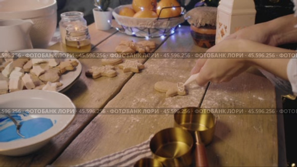 Pastry chef creates New Year's gingerbread cookies, decorating them in various shapes and adding a unique flavor by applying glaze. Стоковое видео, видеограф Strunov David / Фотобанк Лори