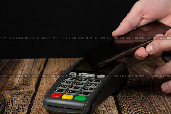 Payment terminal .Payment by mobile phone through a terminal in the store. Стоковое фото, фотограф Александр Поташев / Фотобанк Лори