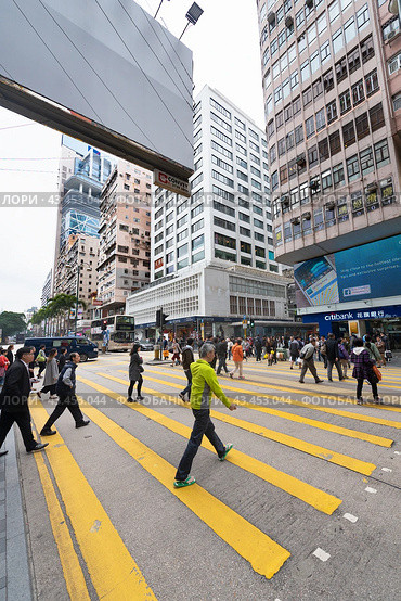People cross a road in Tsim Sha Tsui, Hong Kong (2017 год). Редакционное фото, фотограф Александр Подшивалов / Фотобанк Лори