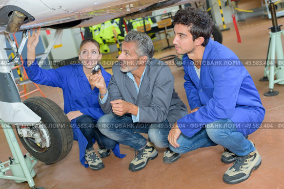 People looking at underside of aircraft. Стоковое фото, агентство Ingram Publishing / Фотобанк Лори
