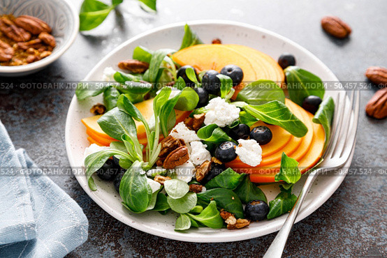 Persimmon fruit salad with blueberry, pecan nuts and ricotta chesse. Healthy food. Top view. Стоковое фото, агентство Ingram Publishing / Фотобанк Лори