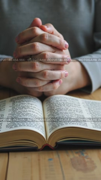 Person is praying with their hands on their lap in front of a Bible. Стоковое AI-видео, аниматор Sergey Grishin / Фотобанк Лори