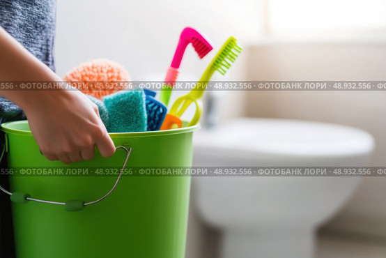 Person is standing in the WC holding a blue bucket full of chemicals, cleaning supplies and facilities for cleansing. Clean toilet. Neat restroom. House cleanliness, service. White ceramic toilet bowl. Стоковое AI-изображение, AI-художник Марина Демидюк / Фотобанк Лори