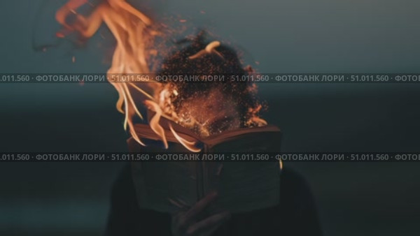 Person reading a book that is on fire during sunset, showcasing a powerful and emotional moment of destruction. Стоковое AI-видео, аниматор Сергей Толмачёв / Фотобанк Лори