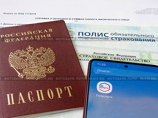Персональные данные гражданина РФ: паспорт, медицинский полис, СНИЛС и телефон с электронным приложением Государственные слуги (2023 год). Редакционное фото, фотограф Татьяна Т / Фотобанк Лори