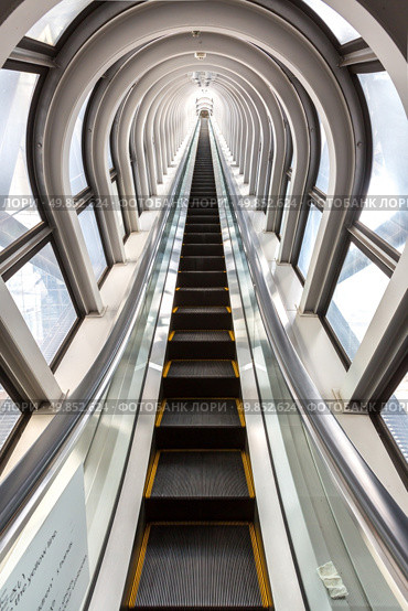 perspective escalators stairway inside contemporary blue glass business centre, concept of successful career elevation. Стоковое фото, агентство Ingram Publishing / Фотобанк Лори