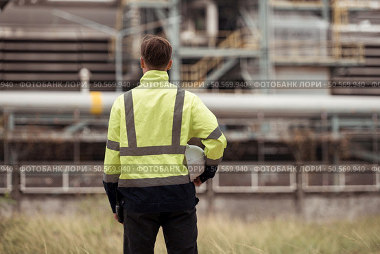 Petroleum engineer is on a mission to inspect oil distillation at a huge oil refinery. Стоковое фото, агентство Ingram Publishing / Фотобанк Лори
