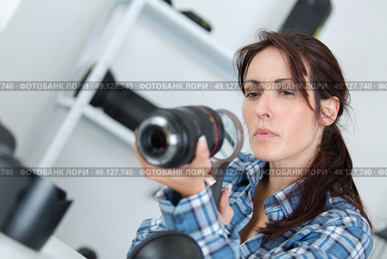 photographer checking a lens with a magnifying glass. Стоковое фото, агентство Ingram Publishing / Фотобанк Лори