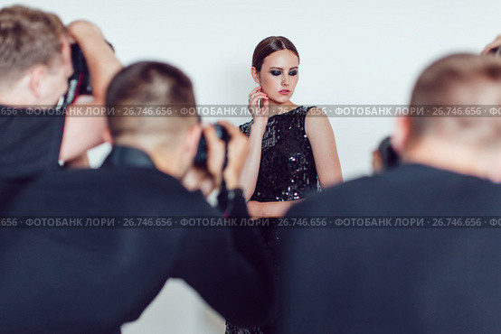 Photographers paparazzi take photos of woman in cocktail dresses. Стоковое фото, фотограф Женя Канашкин / Фотобанк Лори