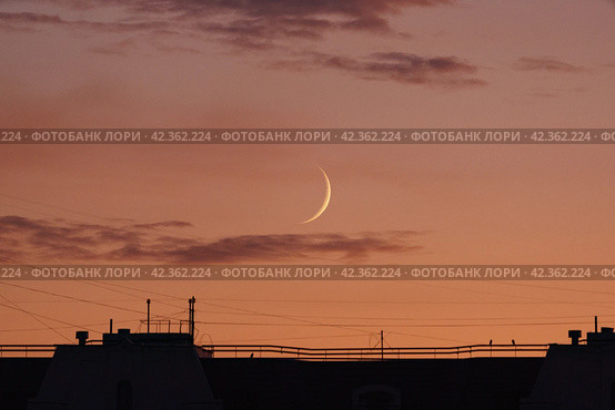 Photography of the roofs of houses and growing moon over Moscow in the sunset. Lifestyles concepts. The city is shrouded in electromagnetic waves of different lengths. Concepts of danger for health. (2019 год). Стоковое фото, фотограф YuryKara / Фотобанк Лори