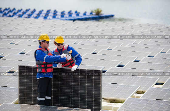 Photovoltaic engineers work on floating photovoltaics. Inspect and repair the solar panel equipment floating on the water. Стоковое фото, агентство Ingram Publishing / Фотобанк Лори