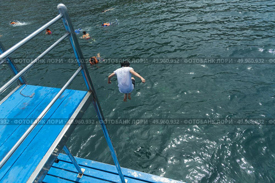 Phuket, THAILAND - JANUARY 4, 2017. A tourist wearing a bikini swim in the sea in Phuket. Редакционное фото, агентство Ingram Publishing / Фотобанк Лори