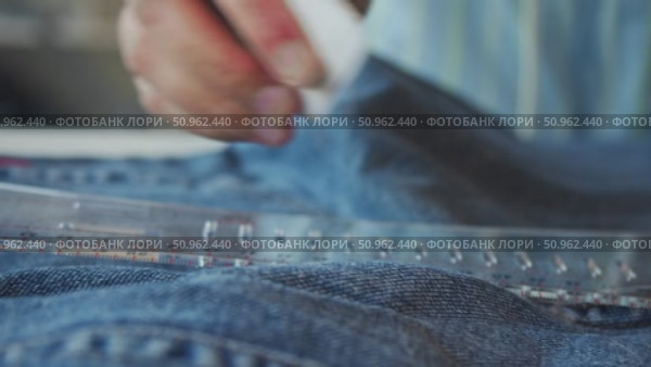 Piece of chalk employed by dressmaker to trace line on denim garments, which tailor can then use as reference for their work. Стоковое видео, видеограф Strunov David / Фотобанк Лори