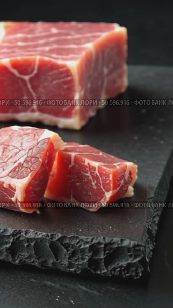 Pieces of raw fresh meat isolated on black on stone board mirrored side view. Стоковое AI-видео, аниматор Sergey Grishin / Фотобанк Лори