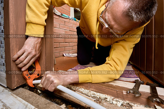 Pipe is being cut with ratchet cutter by plumber to prepare clean edge on multilayer tubing before installation of compression fitting coupling. Стоковое фото, фотограф Владимир Григорьев / Фотобанк Лори