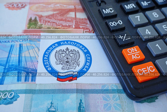 Письмо с эмблемой Федеральной налоговой службы, калькулятор и российские деньги (2023 год). Редакционное фото, фотограф Цибаев Алексей / Фотобанк Лори
