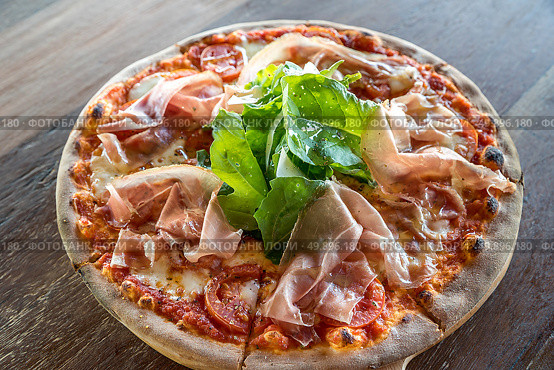 pizza parma ham and rocket salad on wooden table. Стоковое фото, агентство Ingram Publishing / Фотобанк Лори