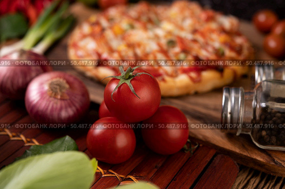 Pizza with sausage, corn, beans, shrimp and bacon on a wooden plate. Стоковое фото, агентство Ingram Publishing / Фотобанк Лори