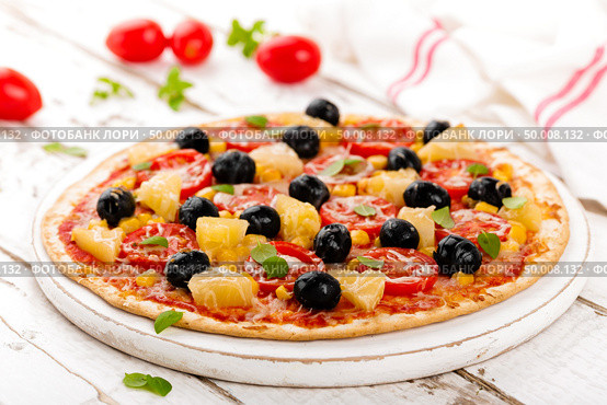 Pizza with tomatoes, mozzarella cheese, olives, corn and basil. Traditional italian cuisine. Стоковое фото, агентство Ingram Publishing / Фотобанк Лори