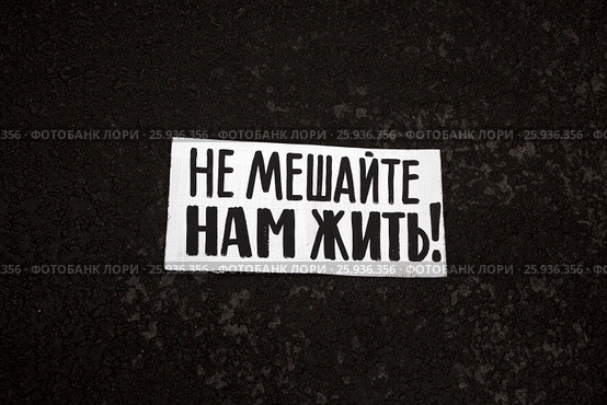 Плакат "Не мешайте нам жить!" лежит на асфальте на митинге москвичей против сноса пятиэтажек в городе Москве, Россия (2017 год). Стоковое фото, фотограф Николай Винокуров / Фотобанк Лори