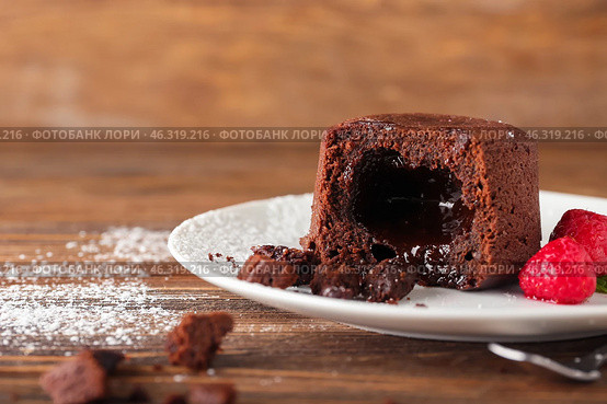 Plate with tasty lava cake fondant and raspberry on wooden background, closeup. Стоковое фото, фотограф Pixel_shot / Фотобанк Лори