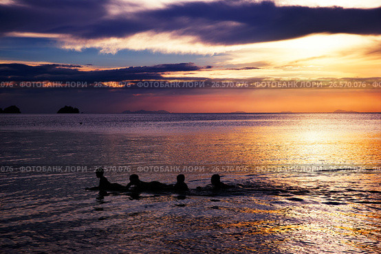 Playing and swimming kids in sea over beautifil sunrise in Thai. Стоковое фото, фотограф Roman Barelko / Фотобанк Лори