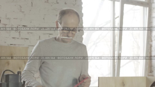 Плотник закрепляет кусок доски на станке. Стоковое видео, видеограф Александр Багно / Фотобанк Лори