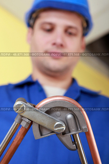 Plumber bending copper pipe. Стоковое фото, агентство Ingram Publishing / Фотобанк Лори