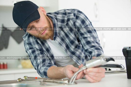 plumber installing sink siphon in domestic bathroom. Стоковое фото, агентство Ingram Publishing / Фотобанк Лори