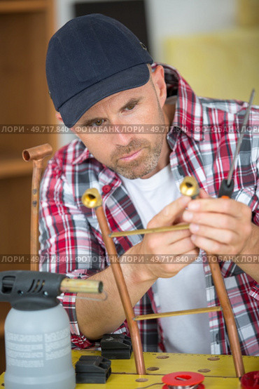 plumber using welding gas torch to solder copper pipes. Стоковое фото, агентство Ingram Publishing / Фотобанк Лори